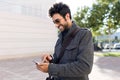 Modern young man using his mobile phone in the street. Royalty Free Stock Photo