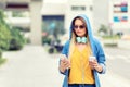 Modern young woman in big city using mobile phone while walking on street Royalty Free Stock Photo