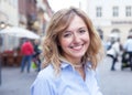 Modern young woman with curly blond hair in the city Royalty Free Stock Photo