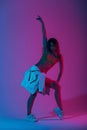 Modern young woman dancer in fashionable youth clothes in a white sneakers dancing in a room with blue light. Sexy pretty Royalty Free Stock Photo