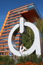 Modern young woman on the steps of symbol of Information Technology Center in Akademgorodok. The symbol of Novosibirsk technopark