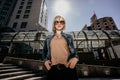 Modern young woman in sunglasses on the background of skyscrapers. Life in the modern city