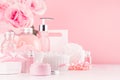 Modern youth bathroom or dressing table design in pastel pink color - fresh pink flowers, cosmetic products, bath accessories.