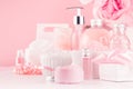 Modern youth bathroom or dressing table design in pastel pink color - fresh pink flowers, cosmetic products, bath accessories. Royalty Free Stock Photo