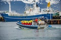 Modern Zodiac boat for big group of tourists is leaving the harbor of Husavik for whale watching safari, Iceland