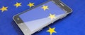 Modern smartphone lies on the EU flag
