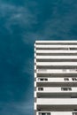 Modernist residential building with white balconies. Concrete architecture against the blue sky Royalty Free Stock Photo