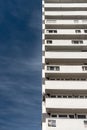 Modernist residential building with white balconies. Concrete architecture against the blue sky Royalty Free Stock Photo