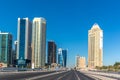 Moderns buildings under construction in downtown Doha in a blue sky day in Qatar, street perspective.