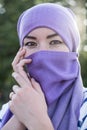 A modest Afghan woman in a purple hijab