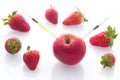 Modified food, fruits,apple and strawberries with punched needles and syringes Royalty Free Stock Photo