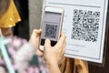 Modified inactive QR Code used. Person scanning QR code with smartphone to register details before enter outlet to comply with