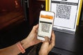 Modified inactive QR Code used. Person scanning QR code with smartphone to register details before enter outlet to comply with