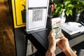 Modified inactive QR Code used. Person scanning QR code with smartphone to register details before enter outlet to comply with