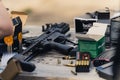 2022.08.07 Modlin, Poland - Submachine gun and various bullets and clips stored in cardboard boxes on wooden table