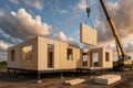 Modular home construction with crane lifting wall panel on sunny day. concept of modern architecture, efficient building Royalty Free Stock Photo