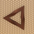 Moebius strib shaped triangle on patterned beige background