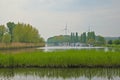 Moervaart canal in the Flemish countryside, with leisure boats and wind turbines Royalty Free Stock Photo