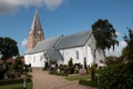 Mogeltonder church with white walls and a big bell tower and a cemetery around it in a small