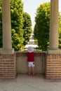 Mogosoaia, Romania - August 05, 2018: young girl looking at the alley entrance at Mogosoaia Palace near Bucharest, Romania.