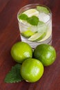Mohito cocktail surrounded by limes