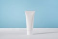 Moisturiser hand cosmetic cream white plastic tube mockup on blue background front view. Blank body and health care Royalty Free Stock Photo