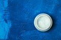 Moisturizer cream bottle on a textured classic blue background