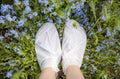 Moisturizing foot mask for dry heels feet. Woman wearing one time moisturizing foot mask socks outdoors standing between wild. Royalty Free Stock Photo