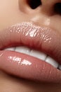 Moisturizing lip balm, lipstick. Close-up of a beautiful wet lips. Full lips with gloss makeup. Filler Injections