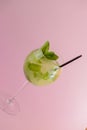 Mojito alcohol cocktail with plastic straw, tropical beverage with ice, mint and lime on pink background, copy space. Royalty Free Stock Photo