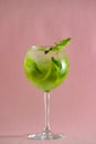 Mojito alcohol cocktail, tropical beverage with ice, mint and lime on pastel pink background with copy space. Royalty Free Stock Photo