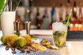 Mojito cocktail on bar counter with lemons, limes and species with copy space for text. Royalty Free Stock Photo