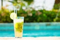 Mojito cocktail at the edge of a resort pool. Concept of luxury