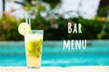 Mojito cocktail at the edge of a resort pool. Concept of luxury vacation. Bar menu wording Royalty Free Stock Photo