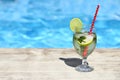 Mojito cocktail at the edge of a resort pool. Concept of luxury vacation