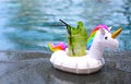 Mojito cocktail at the edge of a resort pool in inflatable unicorn. Concept of luxury vacation Royalty Free Stock Photo