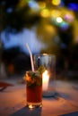 A mojito cocktail glass on a background of a burning candle on a table in a restaurant with evening lighting