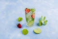 Mojito cocktail with ice cubes. Glass of Summer lemonade or ice tea. Refreshing cool detox drink with strawberry, lime and mint on Royalty Free Stock Photo