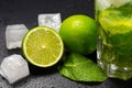 Mojito cocktail with ice, fresh mint and lime on a dark background, close-up. A refreshing summer alcoholic drink Royalty Free Stock Photo