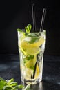 Mojito cocktail or lemonade with lime and mint in highball glass on black table. Close up. Summer drink Royalty Free Stock Photo
