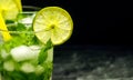 Mojito cocktail with lime and mint in glass on a grey stone background. Copy space Royalty Free Stock Photo