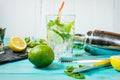Mojito cocktail with lime and mint in highball glass on a blue wood table. Drink making tools and ingredients for cocktail Royalty Free Stock Photo