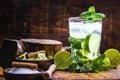 Mojito cocktail with lime, rum and mint in the tall glass on a rustic wooden table. Summer drink made in Havana Royalty Free Stock Photo