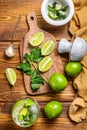 Mojito cocktail making. Ingredients Mint, lime, ice and bar utensils. Wooden background. Top view Royalty Free Stock Photo