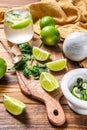 Mojito cocktail making. Ingredients Mint, lime, ice and bar utensils. Wooden background. Top view Royalty Free Stock Photo