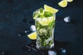 Mojito cocktail or mocktail with lime, mint, and ice in glass on blue background. Summer cold alcoholic non-alcoholic drink, Royalty Free Stock Photo