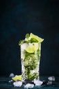 Mojito cocktail or mocktail with lime, mint, and ice in glass on blue background. Summer cold alcoholic non-alcoholic drink, Royalty Free Stock Photo