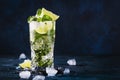 Mojito cocktail or mocktail with lime, mint, and ice in glass on blue background. Summer cold alcoholic non-alcoholic drink, Royalty Free Stock Photo