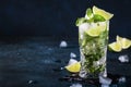 Mojito cocktail or mocktail with lime, mint, and ice in glass on blue background. Summer cold alcoholic non-alcoholic drink, Royalty Free Stock Photo