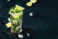 Mojito cocktail or mocktail with lime, mint, and ice in glass on blue background. Summer cold alcoholic non-alcoholic drink, Royalty Free Stock Photo